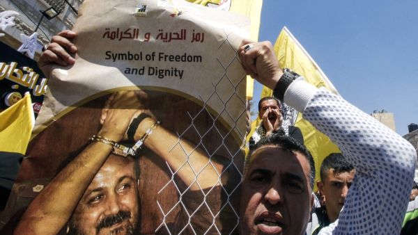 متظاهر فلسطيني يحمل صورة للأسير مروان البرغوثي