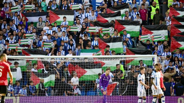 Supporters hold Palestinian flags during the Spanish league football match between Real Sociedad and RCD Mallorca at the Reale Arena stadium in San Sebastian on October 21, 2023. (Photo by ANDER GILLENEA / AFP)