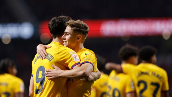 Barcelona's Spanish midfielder #32 Fermin Lopez celebrates scoring his team's third goal with Barcelona's Polish forward #09 Robert Lewandowski during the Spanish league football match between Club Atletico de Madrid and FC Barcelona at the Metropolitano stadium in Madrid on March 17, 2024. (Photo by OSCAR DEL POZO / AFP)