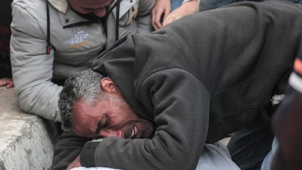 رجل فلسطيني ينعي جثة قريب له استشهد خلال القصف الإسرائيلي على دير البلح