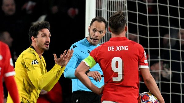 Dortmund's German defender #15 Mats Hummels (L) reacts towards PSV's Dutch forward #09 Luuk de Jong during a penalty shoot following Hummels' foul as Serbian football referee Srdan Jovanovic looks on during the UEFA Champions League round of 16, first leg football match between against PSV Eindhoven and Borussia Dortmund at the The Philips Stadium, in Eindhoven on February 20, 2024. (Photo by JOHN THYS / AFP)