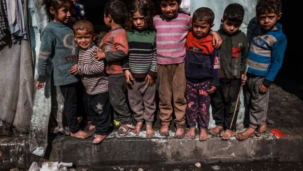 Displaced Palestinian children pose for photos standing in front of makeshift tents at a camp beside a street in Rafah on March 14, 2024, amid ongoing battles between Israel and the Hamas militant group. The Israel-Hamas conflict raging since October 7 has caused mass civilian deaths, reduced vast areas to a rubble-strewn wasteland and sparked warnings of looming famine in the Palestinian territory of 2.4 million people. (Photo by Mohammed ABED / AFP) Gaza Children
