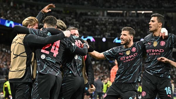 Manchester City's players celebrate English midfielder #47 Phil Foden second goal during the UEFA Champions League quarter final first leg football match between Real Madrid CF and Manchester City at the Santiago Bernabeu stadium in Madrid on April 9, 2024. (Photo by JAVIER SORIANO / AFP)