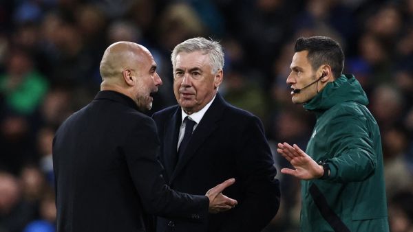 Manchester City's Spanish manager Pep Guardiola (L) and Real Madrid's Italian coach Carlo Ancelotti (C) speak with an official during the UEFA Champions League quarter-final second-leg football match between Manchester City and Real Madrid, at the Etihad Stadium, in Manchester, north-west England, on April 17, 2024. (Photo by Darren Staples / AFP)