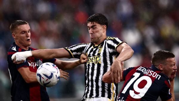 Juventus Serbian forward Dusan Vlahovic (C) fights for the ball with Bologna Swiss midfielder Michel Aebischer (L) and Bologna Scottish midfielder Lewis Ferguson during the Italian Serie A football match Juventus vs Bologna on August 27, 2023 at the “Allianz Stadium” in Turin. (Photo by MARCO BERTORELLO / AFP)