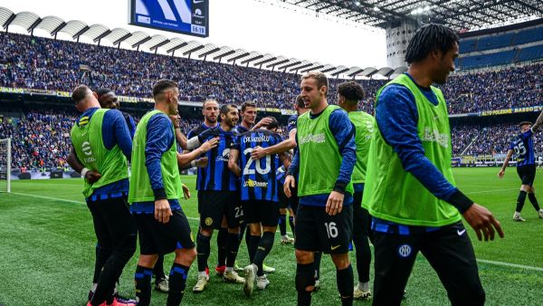 Inter Milan's Turkish midfielder #20 Hakan Calhanoglu celebrates with teammates after scoring his team second goal during the Italian Serie A football match between Inter Milan and Torino at the San Siro Stadium in Milan, on April 28, 2024. Inter clinched their 20th Scudetto with a 2-1 victory over AC Milan on April 22, 2024. (Photo by Piero CRUCIATTI / AFP)
