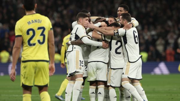Real Madrid's players celebrate their second goal scored by Brazilian forward #11 Rodrygo during the Spanish league football match between Real Madrid CF and Villarreal CF at the Santiago Bernabeu stadium in Madrid on December 17, 2023. (Photo by Thomas COEX / AFP)