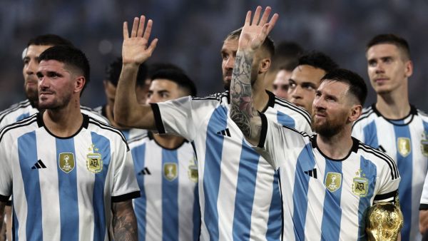 Argentina's forward Lionel Messi (R) waves at the crowd while holding a replica of the World Cup trophy next to his teammates during a recognition ceremony for the World Cup-winning players, following the friendly football match between Argentina and Curacao at the Madre de Ciudades stadium in Santiago del Estero, in northern Argentina, on March 28, 2023. (Photo by Alejandro PAGNI / AFP)