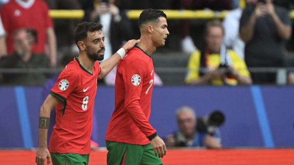 Portugal's midfielder #08 Bruno Fernandes celebrates with Portugal's forward #07 Cristiano Ronaldo (R) after scoring his team's third goal during the UEFA Euro 2024 Group F football match between Turkey and Portugal at the BVB Stadion in Dortmund on June 22, 2024. (Photo by PATRICIA DE MELO MOREIRA / AFP)