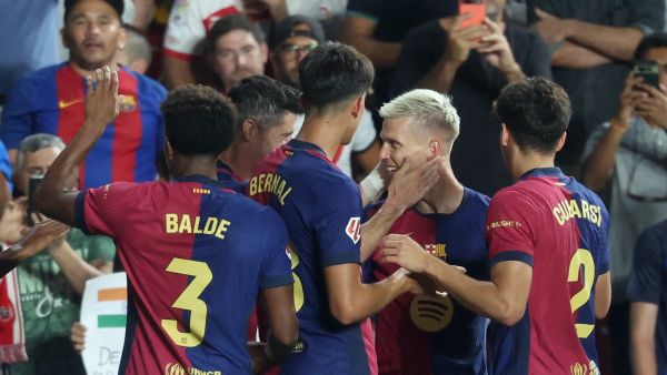 Barcelona's Spanish midfielder #20 Dani Olmo celebrates with teammates scoring his team's second goal during the Spanish league football match between Rayo Vallecano de Madrid and FC Barcelona on August 27, 2024. (Photo by Pierre-Philippe MARCOU / AFP)