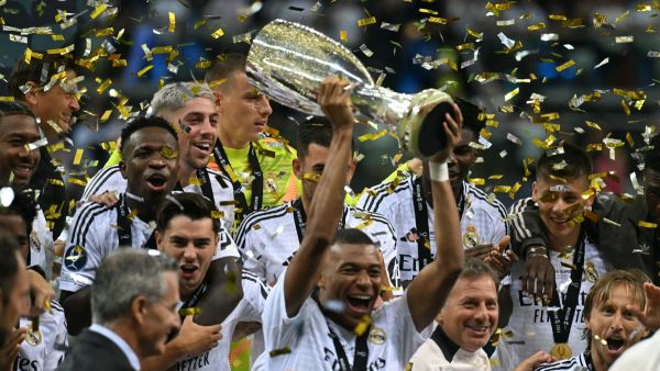 Real Madrid's French forward #09 Kylian Mbappe celebrates with the trophy after the UEFA Super Cup football match between Real Madrid and Atalanta BC in Warsaw, on August 14, 2024. (Photo by Sergei GAPON / AFP)