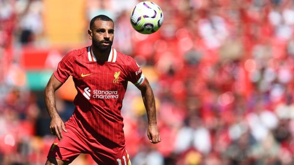 Liverpool's Egyptian striker #11 Mohamed Salah focuses on the ball during the pre-season friendly football match between Liverpool and Sevilla at Anfield stadium in Liverpool, northwest England on August 11, 2024. (Photo by Peter POWELL / AFP)