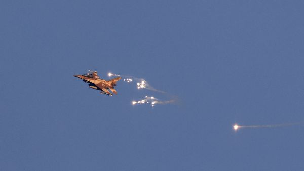 This photo taken from a position in northern Israel shows an Israeli Air Force fighter jet firing flares as it flies to intercept a hostile aircraft that launched from Lebanon over the border area with south Lebanon on August 25, 2024. (Photo by Jalaa MAREY / AFP) South Lebanon
