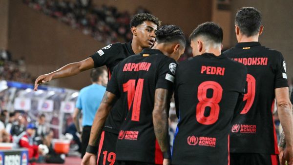 Barcelona's Spanish forward #19 Lamine Yamal (L) celebrates with teammates after scoring his team's first goal during the UEFA Champions League 1st round day 1 football match between AS Monaco and FC Barcelona at the Louis II Stadium in the Principality of Monaco on September 19, 2024. (Photo by Miguel MEDINA / AFP)