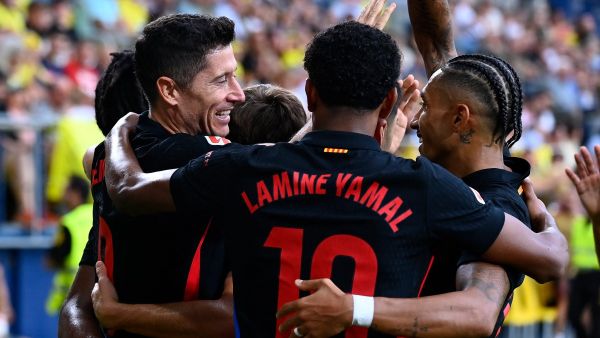 Barcelona's Polish forward #09 Robert Lewandowski celebrates with teammates after scoring his team's first goal during the Spanish league football match between Villarreal CF and FC Barcelona at La Ceramica stadium in Vila-real, on September 22, 2024. (Photo by JOSE JORDAN / AFP)