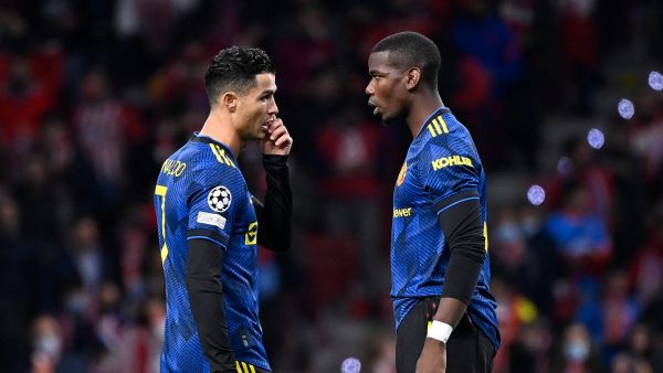 Manchester United's Portuguese forward Cristiano Ronaldo (L) speaks with Manchester United's French midfielder Paul Pogba before the start of the UEFA Champions League football match between Atletico de Madrid and Manchester United at the Wanda Metropolitano stadium in Madrid on February 23, 2022. (Photo by OSCAR DEL POZO / AFP)