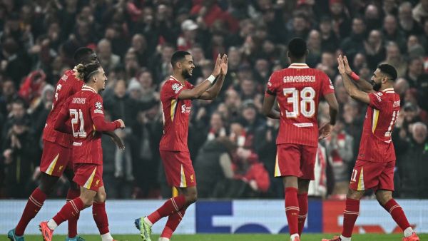 Liverpool's Dutch striker #18 Cody Gakpo (C) celebrates after scoring his team second goal during the UEFA Champions League football match between Liverpool and Bayer Leverkusen at Anfield stadium, in Liverpool, north west England, on November 5, 2024. (Photo by Paul ELLIS / AFP)