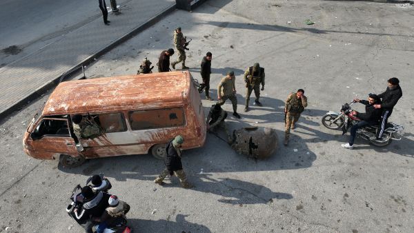  anti government fighters towing a bust of late Syrian president Hafez al-Assad along a street in the city of Hama