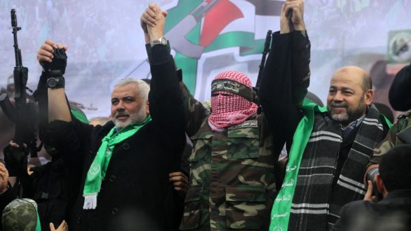 Hamas top leader in the Gaza Strip Ismail Haniya (L), spokesman for the Ezzedine Al-Qassam Brigades, Abu Obaida and Mussa Abu Marzuq (R) greet supporters during a parade marking the 27th anniversary of the Islamist movement’s creation on December 14, 2014 in Gaza City. AFP PHOTO / MAHMUD HAMS Al-Qassam Brigades, Abu Obaida