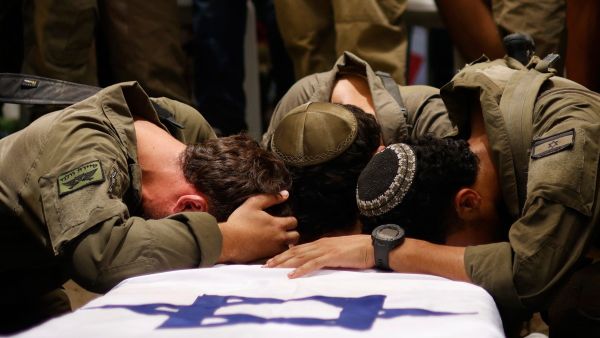 Israeli soldiers mourn over the coffin of army captain Reei Biran, reportedly killed in combat in the southern Gaza Strip the previous day, during his funeral in the northern Israeli Moshav of Nahalal on July 11, 2025. (Photo by Jalaa MAREY / AFP) Israeli soldiers