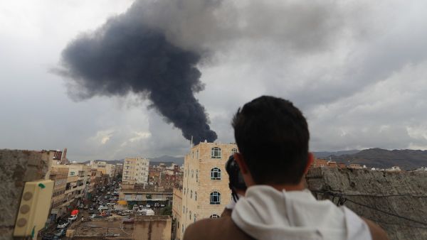 A photojournalist takes a picture of smoke after an Israeli air strike on Yemen's Huthi-held capital Sanaa on August 24, 2025. (Photo by Mohammed HUWAIS / AFP) Houthi Prime Minister