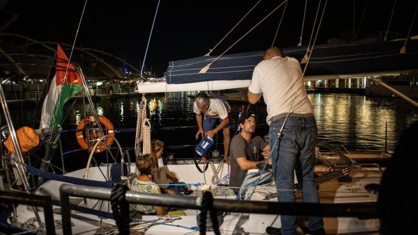 People chat on a boat as they wait to leave for Gaza joining the “Global Sumud Flotilla", in Genoa habor on August 30, 2025. (Photo by Federico SCOPPA / AFP) Sumud