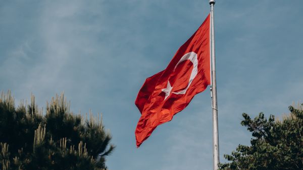 يرفرف العلم الأحمر لتركيا على خلفية السماء الزرقاء