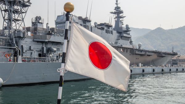 كوري، اليابان – 7 أبريل 2019: يرفرف العلم الياباني في مهب الريح أمام منشأة يابانية