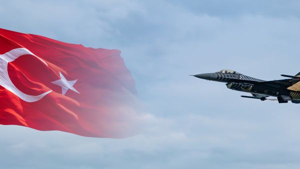 طائرة مقاتلة تركية من طراز سولوتورك F-16 تحلق أمام خلفية علم تركيا.