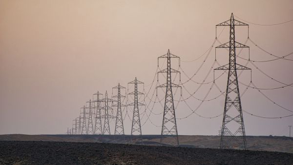 أبراج الكهرباء تمتد على طول الطريق عبر الصحراء المصرية