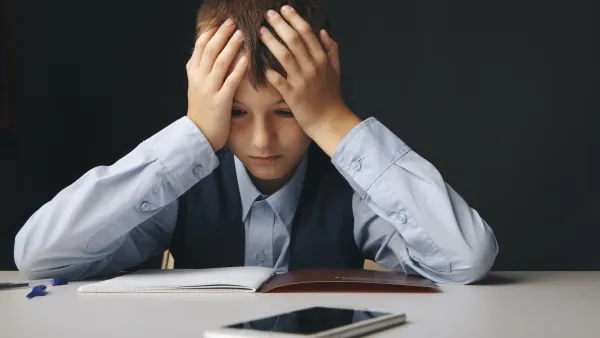 Cyberbullying concept. Stressed and upset school boy with gadget isolated.