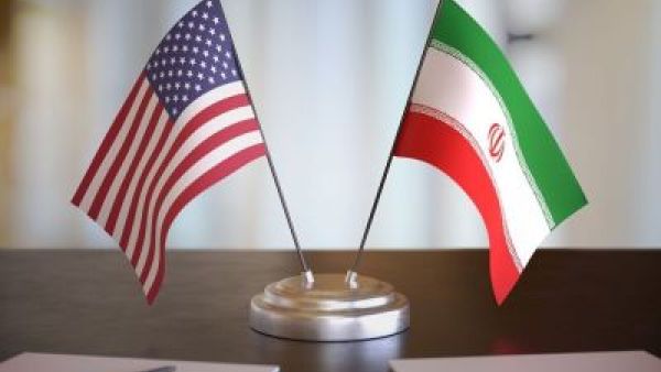 علم الولايات المتحدة وعلم إيران متقابلان في إشارة إلى المفاوضات الجارية بين البلدين بشأن اتفاق محتمل