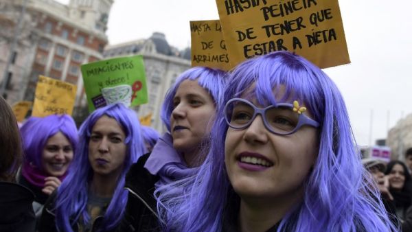 Woman sporting wigs attend a demonstration to defend women's rights on International Women's Day in Madrid, on Mar. 8, 2018. Spain celebrated International Women's Day today with an unprecedented general strike in defense of their rights that saw hundreds of trains cancelled and countless protests scheduled throughout the day.
(OSCAR DEL POZO / AFP)