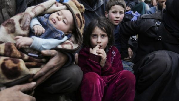 Syrian children sit while awaiting to be evacuated from the Eastern Ghouta enclave through the regime-controlled corridor opened by government forces in Hawsh al-Ashaari, east of the Eastern Ghouta enclave town of Hamouria on the outskirts of the capital Damascus on Mar.15, 2018. Thousands escaped Syria's rebel-held Eastern Ghouta into government-held territory AFP correspondents on both sides said, the largest numbers since the regime assault on the enclave began. (LOUAI BESHARA / AFP)