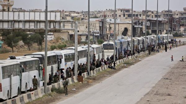 Hundreds of fighters and civilians from Harasta in Syria’s Eastern Ghouta sit on busses on Mar. 23, 2018 after a deal was struck with the opposition to evacuate a second pocket of the rebel enclave on the outskirts of Damascus. Harasta's evacuation came as part of a deal negotiated by Russia, which has played a key role in the deadly offensive launched against the enclave on Feb. 18. (STRINGER / AFP)