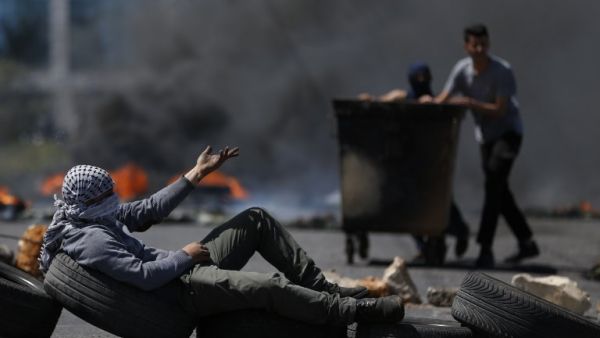 Palestinian men burn tyres during a protest in the West Bank city of Ramallah on Apr. 6, 2018. Clashes erupted on the Gaza-Israel border Friday, AFP journalists said, a week after similar demonstrations led to violence in which Israeli force killed 19 Palestinians, the bloodiest day since a 2014 war. Palestinians burned tyres and threw stones at Israeli soldiers over the border fence, who responded with tear gas and live fire, the correspondents said. (ABBAS MOMANI / AFP)