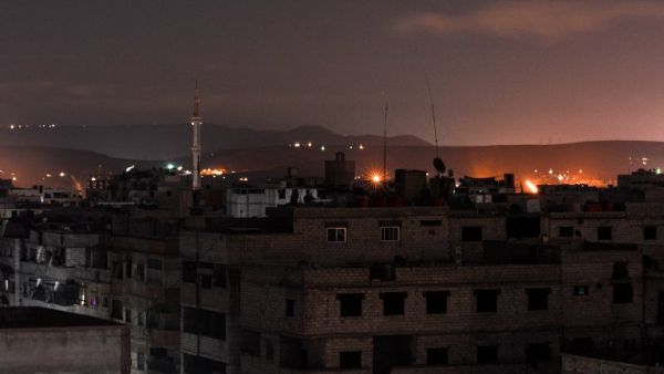 A picture taken early on Apr. 21, 2018 shows explosions appearing in the skyline of a southern district of the Syrian capital Damascus, during regime strikes targeting the Islamic State group in the Palestinian camp of Yarmouk, and neighbouring districts. 
(Rami al SAYED / AFP)