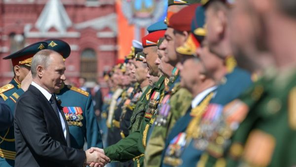 Russian President Vladimir Putin shakes hands with military personnel during the Victory Day parade at Red Square in Moscow on May 9, 2018 / AFP