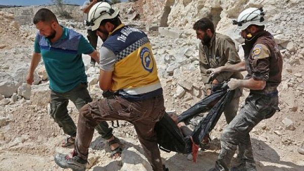 Members of the Syrian Civil Defense, also known as the 'White Helmets,' carrying a victim after airstrikes in Kafr Ain in the Idlib province, September 7, 2018. (AFP/Anas al-Dyab)