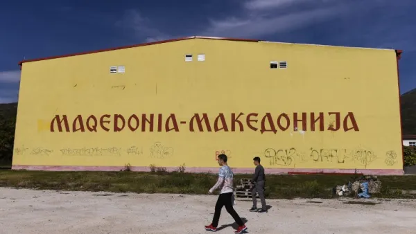 Albanian boys walk past a building reading "Macedonia" (AFP)