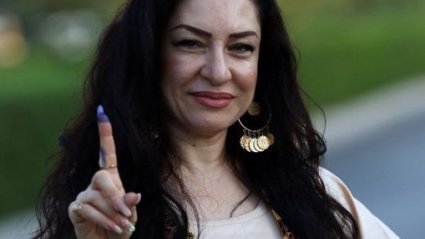 An Iraqi Kurdish woman shows her ink-stained index finger after casting her ballot for the parliamentary election at a polling station in Arbil, the capital of the Kurdish autonomous region in northern Iraq, on September 30, 2018. 
SAFIN HAMED / AFP