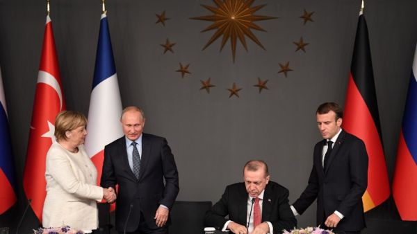 Russian President Vladimir Putin (2ndL) and German Chancellor Angela Merkel (L) shake hands after a conference with Turkish President Recep Tayyip Erdogan (2ndR) and French President Emmanuel Macron (R) during a summit OZAN KOSE / AFP