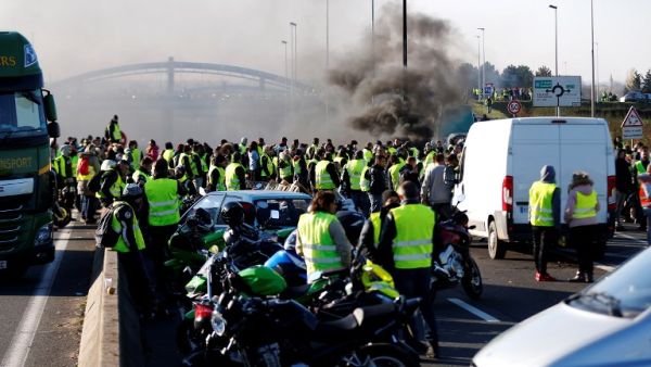 Demonstators of "yellow vests" (Gilets Jaunes) movement block the traffic on Caen's circular road on November 18, 2018 in Caen, western France, a day after a protest against high fuel prices. (CHARLY TRIBALLEAU / AFP)