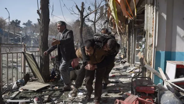 Afghan volunteers carry a body at the scene of a car bomb exploded in front of the old Ministry of Interior building in Kabul on January 27, 2018. (WAKIL KOHSAR / AFP)