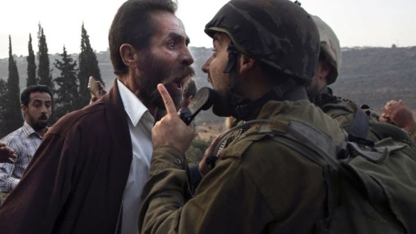 A Palestinian man argues with an Israeli soldier during clashes over an Israeli order to shut down a Palestinian school in the town of as-Sawiyah. (JAAFAR ASHTIYEH / AFP)