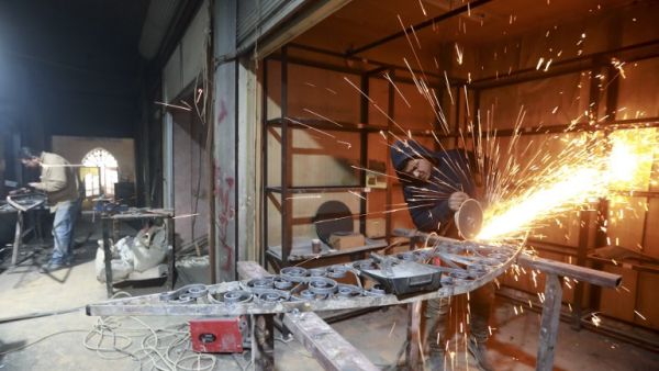 Labourers take part in restoration work at the Saqatiya market in the old quarter of Syria's second city of Aleppo  (AFP)