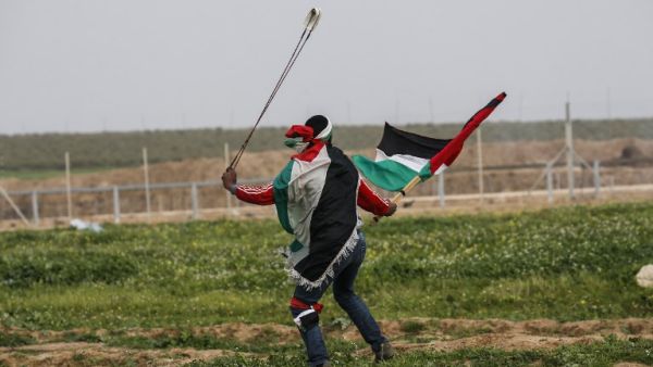 A Palestinian protester uses a slingshot during clashes with Israeli forces. (AFP/ File Photo)
