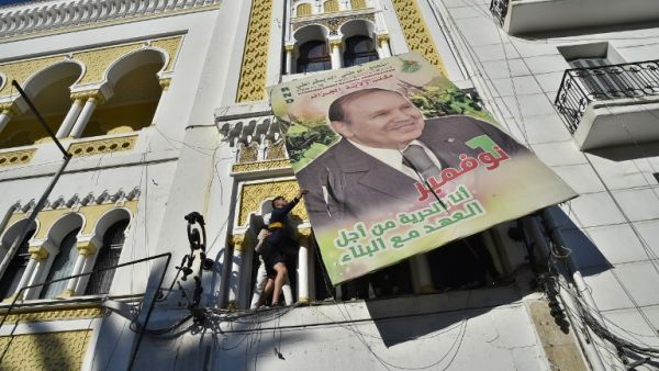 Algerian demonstrators tear down a large billboard with a picture of their current President Abdelaziz Bouteflika on February 22, 2019 in Algiers.(AFP)