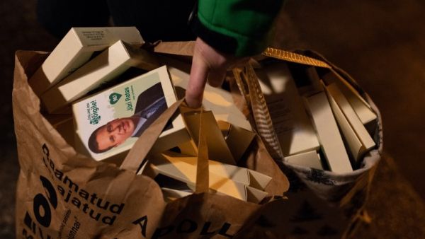 Estonias's Prime Minister Juri Ratas of the centrist Centre party holds a bag full of campaign material as he campaigns (AFP)