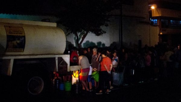 People queue for drinking water being distributed in a tanker in the municipality of Chacao in a tanker, in Caracas, on March 11, 2019.(AFP/ File Photo)